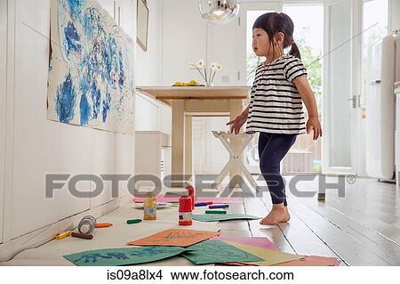Picture - Female toddler inspecting her painting and drawing. Fotosearch