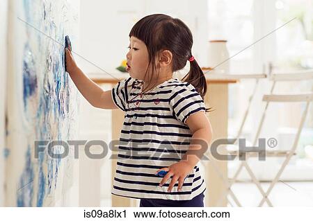 Stock Image - Female toddler making handprint painting. Fotosearch