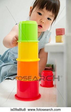 Female toddler on stairs building colorful tower View Large Photo Image Stock Photo - Female toddler on stairs building colorful tower. Fotosearch
