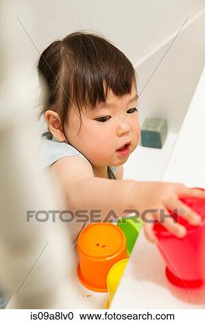 Female toddler playing with toys on staircase View Large Photo Image Stock Image - Female toddler playing with toys on staircase. Fotosearch