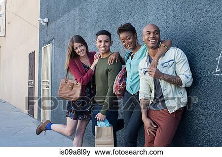 Four friends by grey wall View Large Photo Image Stock Photo - Four friends by grey wall. Fotosearch