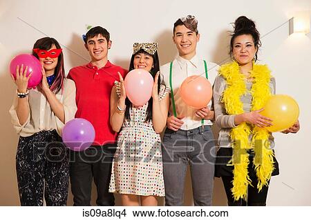 Friends at a party with balloons, studio shot View Large Photo Image Picture - Friends at a party with balloons, studio shot. Fotosearch