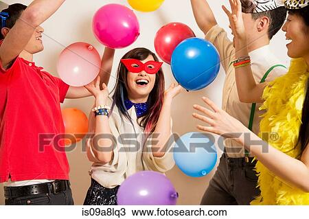 Friends at a party with balloons, studio shot View Large Photo Image Stock Image - Friends at a party with balloons, studio shot. Fotosearch