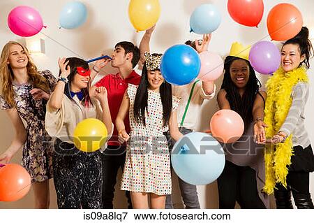 Stock Photo - Friends at a party with balloons, studio shot. Fotosearch
