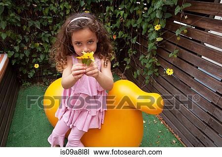 Stock Image - Girl holding flower, portrait. Fotosearch