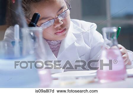 Stock Image - Girl making notes in laboratory. Fotosearch
