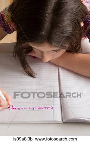 Stock Image - Girl writing in pink felt tip pen in notebook. Fotosearch