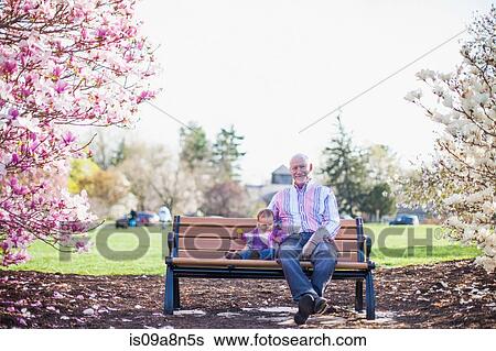 Grandfather and granddaughter sitting on park bench View Large Photo Image Stock Photograph - Grandfather and granddaughter sitting on park bench. Fotosearch