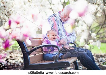 Stock Photograph - Grandfather and granddaughter together in park. Fotosearch