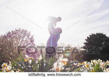 Grandfather holding up granddaughter in garden View Large Photo Image Stock Image - Grandfather holding up granddaughter in garden. Fotosearch
