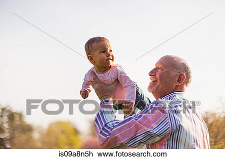 Grandfather holding up granddaughter View Large Photo Image Stock Image - Grandfather holding up granddaughter. Fotosearch