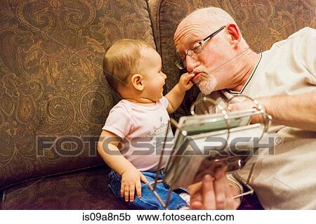 Grandfather playing with baby granddaughter View Large Photo Image Stock Image - Grandfather playing with baby granddaughter. Fotosearch