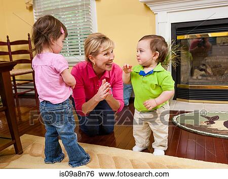 Grandmother and grandchildren playing in dining room View Large Photo Image Stock Photograph - Grandmother and grandchildren playing in dining room. Fotosearch