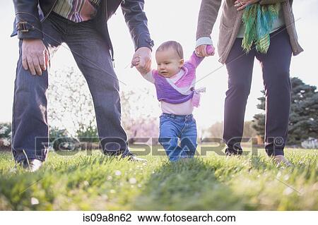 Grandparents holding granddaughter hands in park View Large Photo Image Stock Image - Grandparents holding granddaughter hands in park. Fotosearch