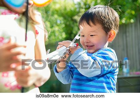 Male toddler in garden with toy airplane View Large Photo Image Stock Image - Male toddler in garden with toy airplane. Fotosearch