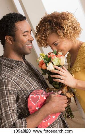 Man giving woman flowers and chocolates on valentines day View Large Photo Image Stock Image - Man giving woman flowers and chocolates on valentines day. Fotosearch