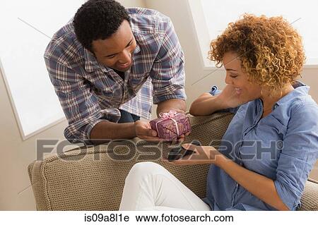 Stock Image - Man giving woman gift box. Fotosearch