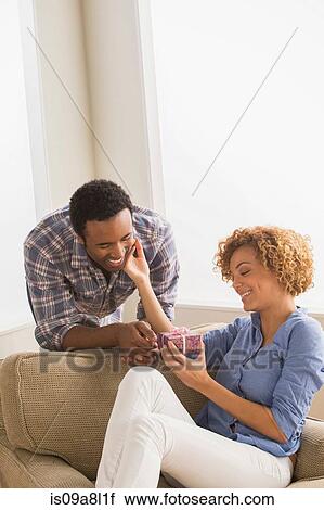 Stock Image - Man giving woman gift box. Fotosearch