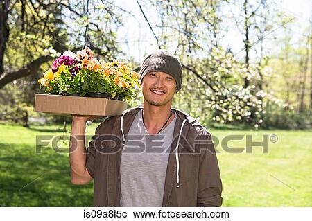 Stock Image - Man holding box of flowers. Fotosearch