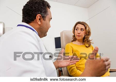 Mature doctor reassuring mid adult patient View Large Photo Image Stock Image - Mature doctor reassuring mid adult patient. Fotosearch