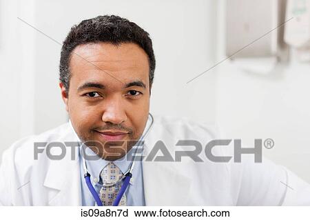 Stock Image - Mature doctor smiling, portrait. Fotosearch