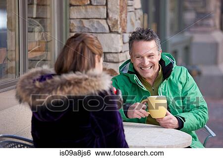 Mature man and woman enjoying drink in pavement cafe View Large Photo Image Stock Photograph - Mature man and woman enjoying drink in pavement cafe. Fotosearch