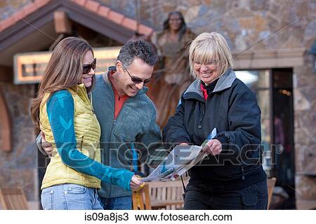 Stock Image - Mature man and young woman asking for directions on map. Fotosearch