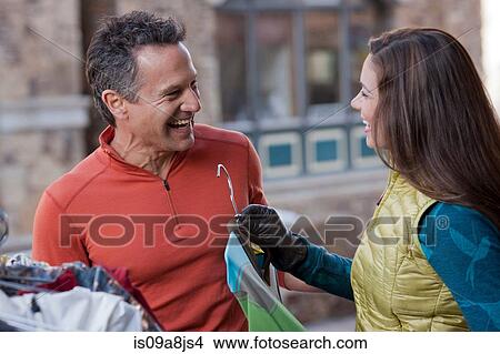 Picture - Mature man and young woman clothes shopping, smiling. Fotosearch