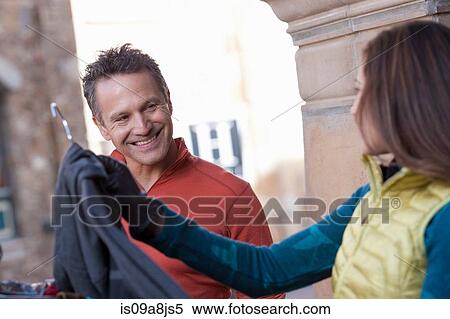 Stock Photography - Mature man and young woman clothes shopping, smiling. Fotosearch