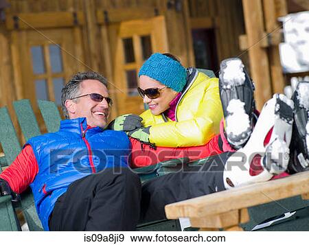 Stock Photo - Mature man and young woman relaxing together in ski resort. Fotosearch