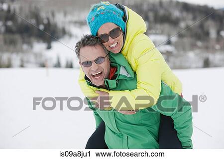 Mature man carrying young woman on back in snow, laughing View Large Photo Image Stock Image - Mature man carrying young woman on back in snow, laughing. Fotosearch