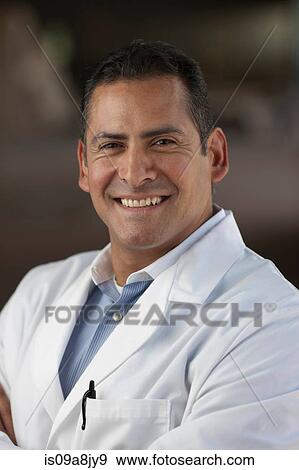 Stock Photo - Mature man wearing lab coat and smiling, portrait. Fotosearch