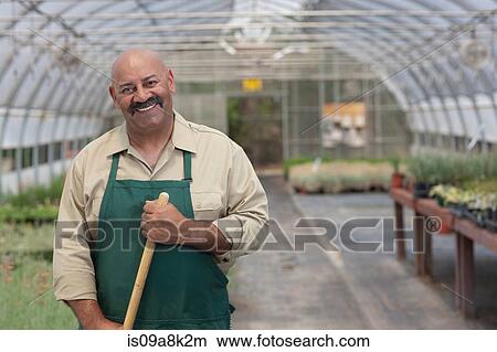 Mature man working in garden centre, portrait View Large Photo Image Picture - Mature man working in garden centre, portrait. Fotosearch