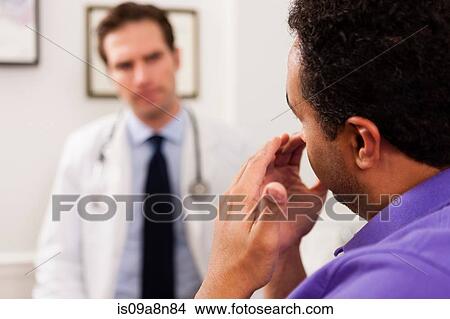 Picture - Mature patient explaining to doctor, close up. Fotosearch