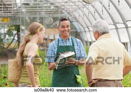 Mature sales assistant serving senior man and mid adult woman in garden centre View Large Photo Image Stock Image - Mature sales assistant serving senior man and mid adult woman in garden centre. Fotosearch