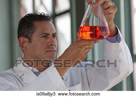 Mature scientist looking at liquid in volumetric flask View Large Photo Image Stock Image - Mature scientist looking at liquid in volumetric flask. Fotosearch