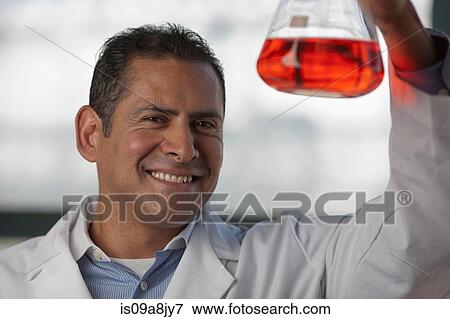 Mature scientist looking at liquid in volumetric flask View Large Photo Image Stock Photo - Mature scientist looking at liquid in volumetric flask. Fotosearch