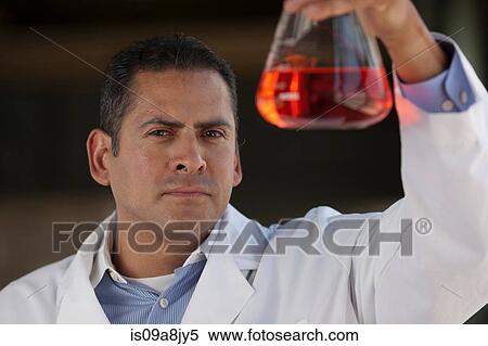 Mature scientist looking at liquid in volumetric flask View Large Photo Image Stock Photography - Mature scientist looking at liquid in volumetric flask. Fotosearch