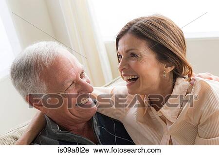 Stock Image - Mature woman and senior man hugging, laughing. Fotosearch