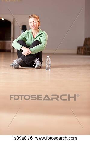 Mature woman sitting on floor, looking away View Large Photo Image Stock Photograph - Mature woman sitting on floor, looking away. Fotosearch