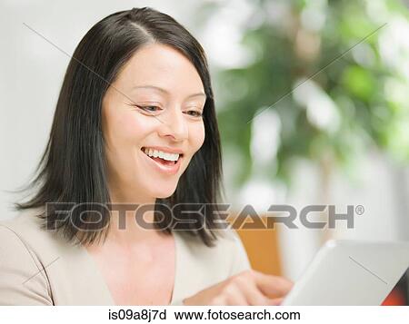 Mature woman using digital tablet and smiling View Large Photo Image Stock Image - Mature woman using digital tablet and smiling. Fotosearch