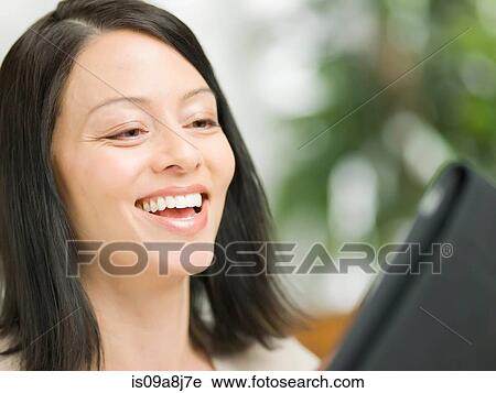 Mature woman using digital tablet and smiling View Large Photo Image Stock Image - Mature woman using digital tablet and smiling. Fotosearch