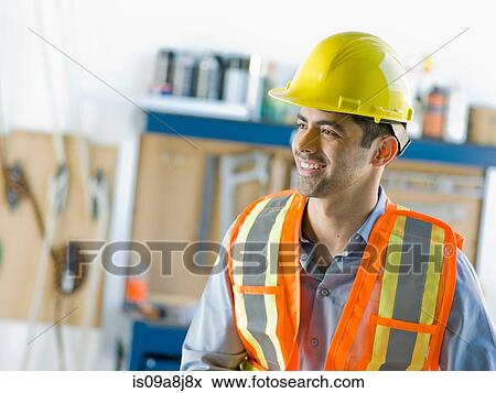 Mid adult construction worker smiling View Large Photo Image Stock Photo - Mid adult construction worker smiling. Fotosearch
