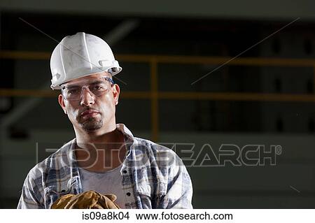 Picture - Mid adult construction worker wearing hard hat, portrait. Fotosearch