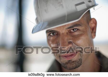 Mid adult construction worker wearing hard hat, looking away View Large Photo Image Stock Image - Mid adult construction worker wearing hard hat, looking away. Fotosearch