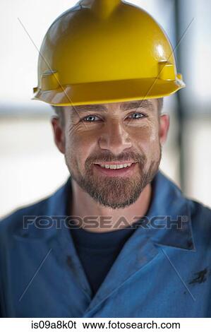 Mid adult construction worker wearing hard hat, smiling View Large Photo Image Stock Photograph - Mid adult construction worker wearing hard hat, smiling. Fotosearch