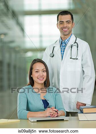 Mid adult doctor and young student smiling, portrait View Large Photo Image Picture - Mid adult doctor and young student smiling, portrait. Fotosearch