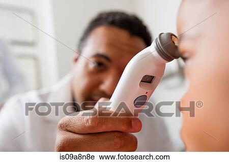 Mid adult doctor using medical equipment on young patient, close up View Large Photo Image Stock Image - Mid adult doctor using medical equipment on young patient, close up. Fotosearch
