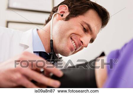 Mid adult doctor using stethoscope and blood pressure cuff on patient, close up View Large Photo Image Stock Photo - Mid adult doctor using stethoscope and blood pressure cuff on patient, close up. Fotosearch