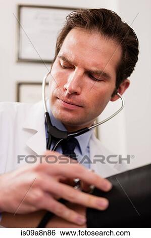 Mid adult doctor using stethoscope and blood pressure cuff on patient, close up View Large Photo Image Stock Photograph - Mid adult doctor using stethoscope and blood pressure cuff on patient, close up. Fotosearch